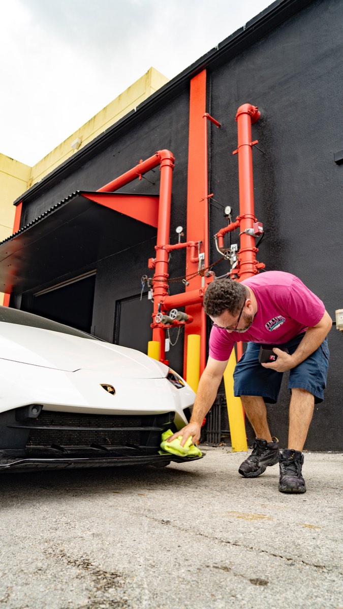 Lulu's Amazing Detail technician hand-finishing a Lamborghini after ceramic coating